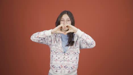 Young-woman-making-heart-sign-at-camera.